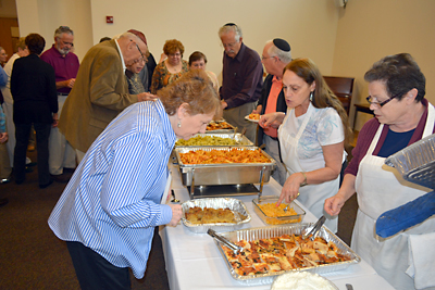 Renee Roth and Bea Horowitz serve the main course on the lunch buffet.